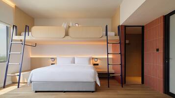 Una habitación de hotel moderna con literas, un escritorio y vistas a la ciudad.