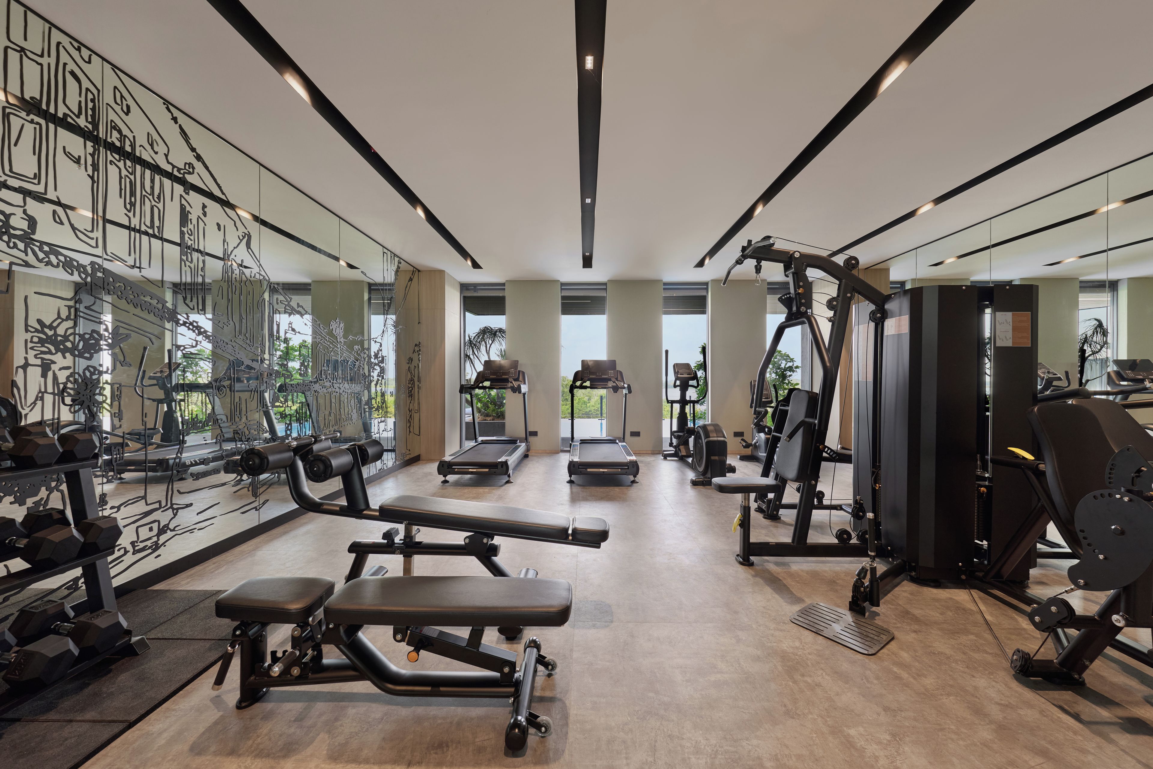 A modern gym with treadmills, weight machines, and free weights.