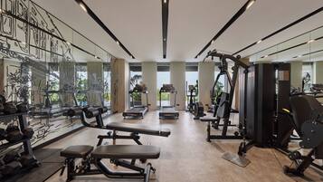 A modern gym with treadmills, weight machines, and free weights.