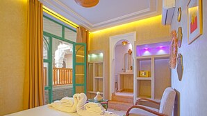 Ein Hotelzimmer mit Bett, Stuhl, Badezimmer und Duschbereich.
