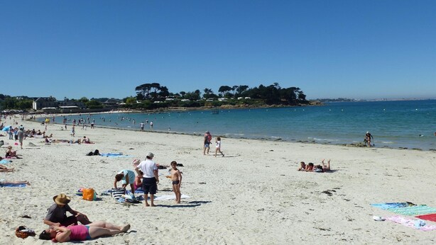 A beach with people sunbathing and swimming, clear skies, and a distant shoreline with trees. - House in Brittany with sea view for 2 people. (Cléder)