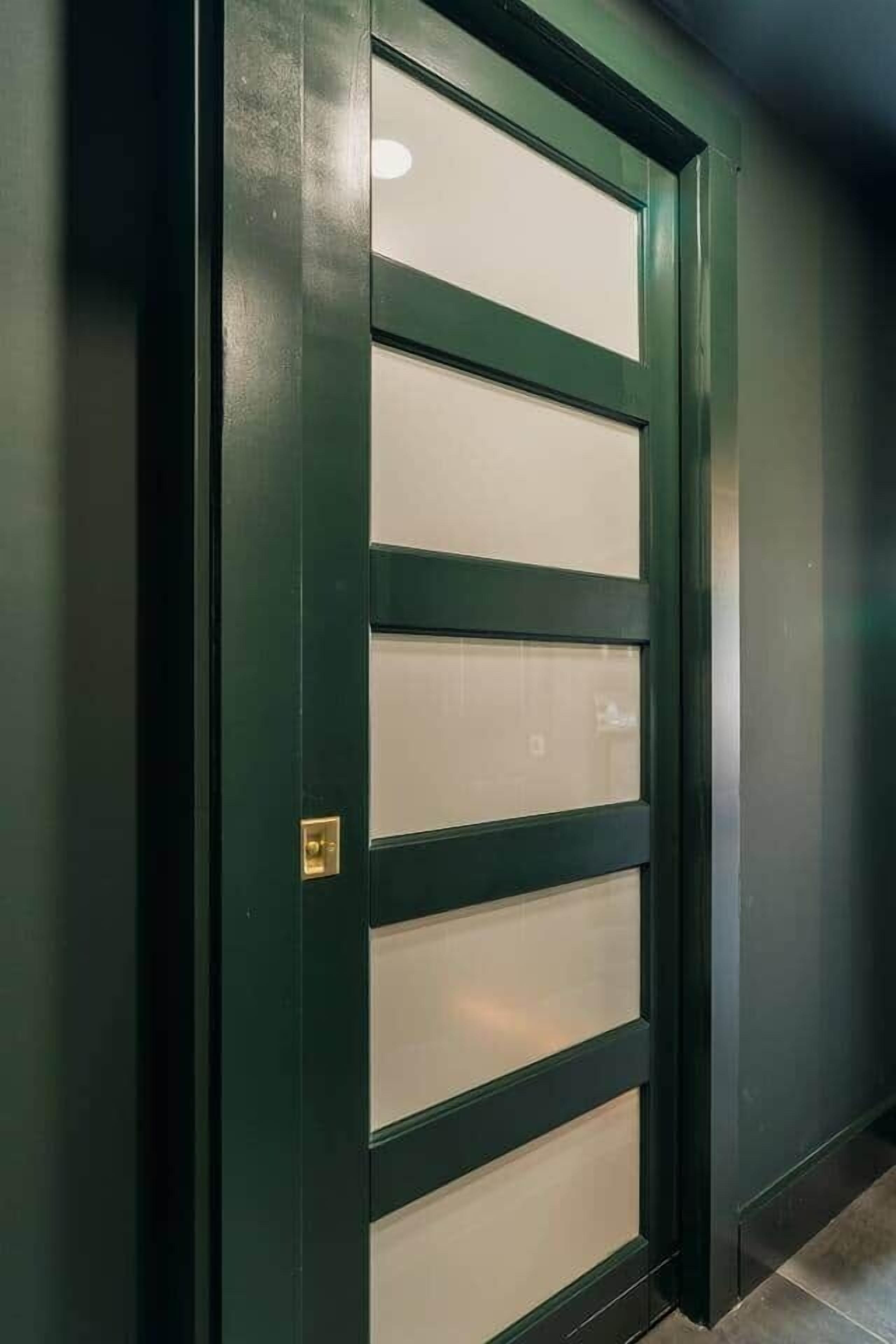 A door with a dark frame and frosted glass panels.