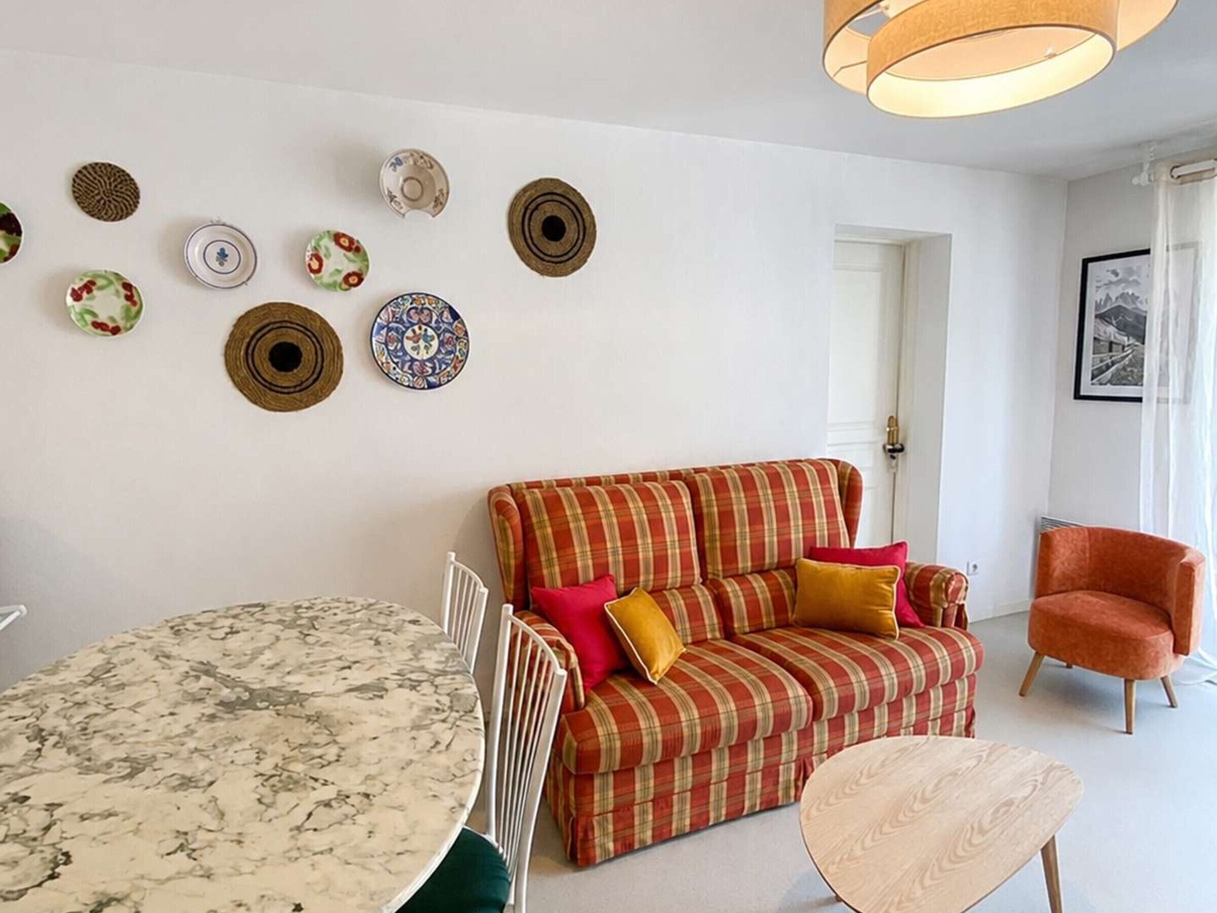 Una sala de estar con una mesa redonda, un sofá y una silla.