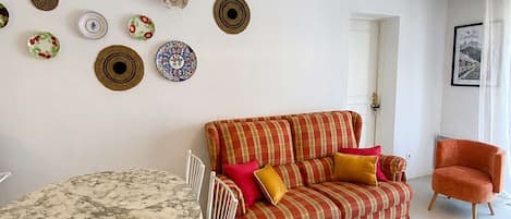 Una sala de estar con una mesa redonda, un sofá y una silla.