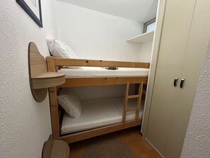 A bunk bed with a shelf attached to the wall, a small table, and a wardrobe. - Studio cabin near beach - 4 guests (Saint-Aygulf)