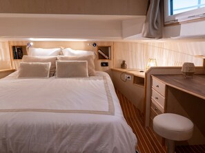 A neatly arranged hotel room with a bed, bedside table, lamp, and a small desk with a chair. - Comfortable houseboat in Digoin - 6 guests (Digoin)