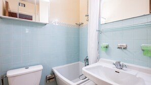 Uma casa de banho com sanita, banheira e lavatório.