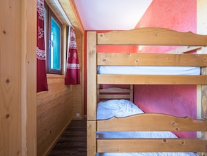 A wooden bunk bed room with a window and curtains. - Cozy studio, station view - 4 guests (La Toussuire)