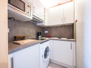 A compact kitchen with a microwave, coffee maker, sink, and washing machine. - Cozy studio, station view - 4 guests (La Toussuire)