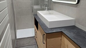 A modern bathroom with a white sink, wooden cabinetry, and a mirror with a lighted frame. - Pleasant apartment, west balcony - 6 guests (Lanslevillard)