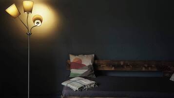Quarto com cama, luminária de chão e parede com textura.