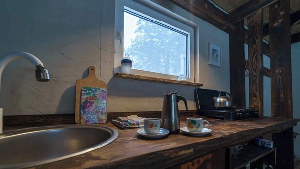 A kitchen with a large sink, a window, a kettle, and a coffee maker. - Point NEMO Digital Detox - Maga Capsule with Sauna (Mirsk)