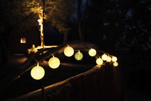 A string of lights on a wooden fence in a dark outdoor setting. - Point NEMO Digital Detox - Maga Capsule with Sauna (Mirsk)