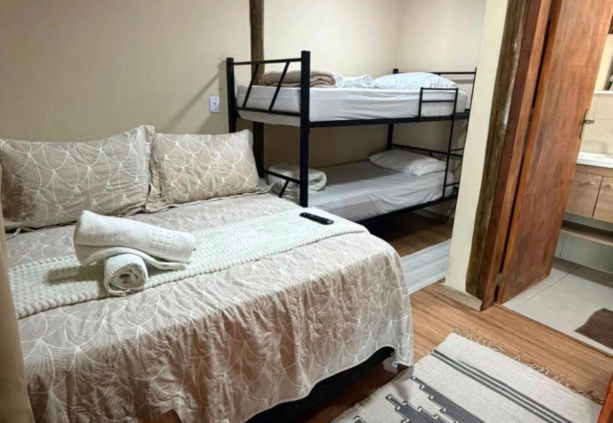 A room with a single bed, a bunk bed, and a wooden floor.