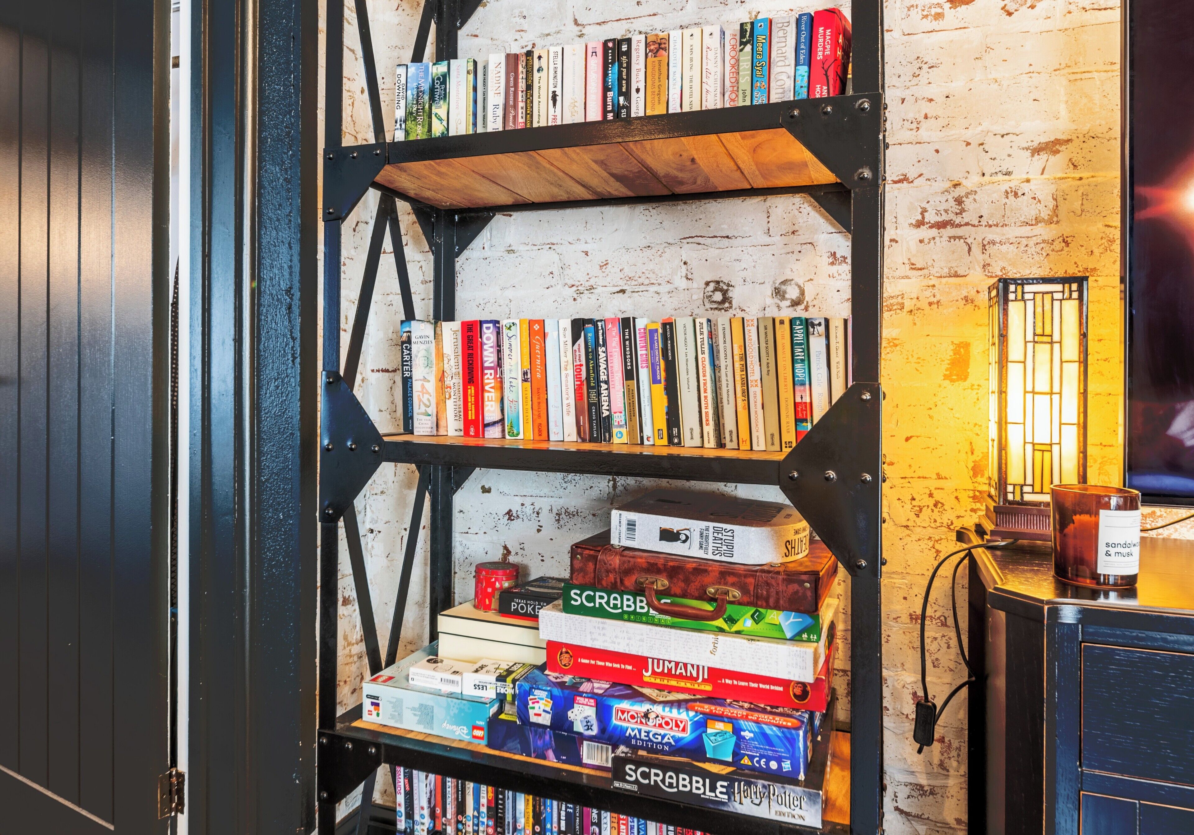 A bookshelf with various books and board games.
