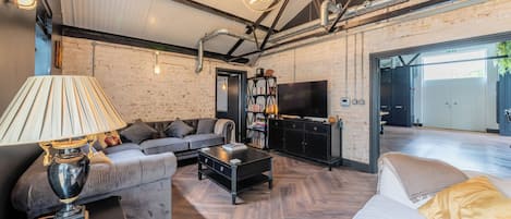 A modern living room with a sofa, coffee table, and a television.