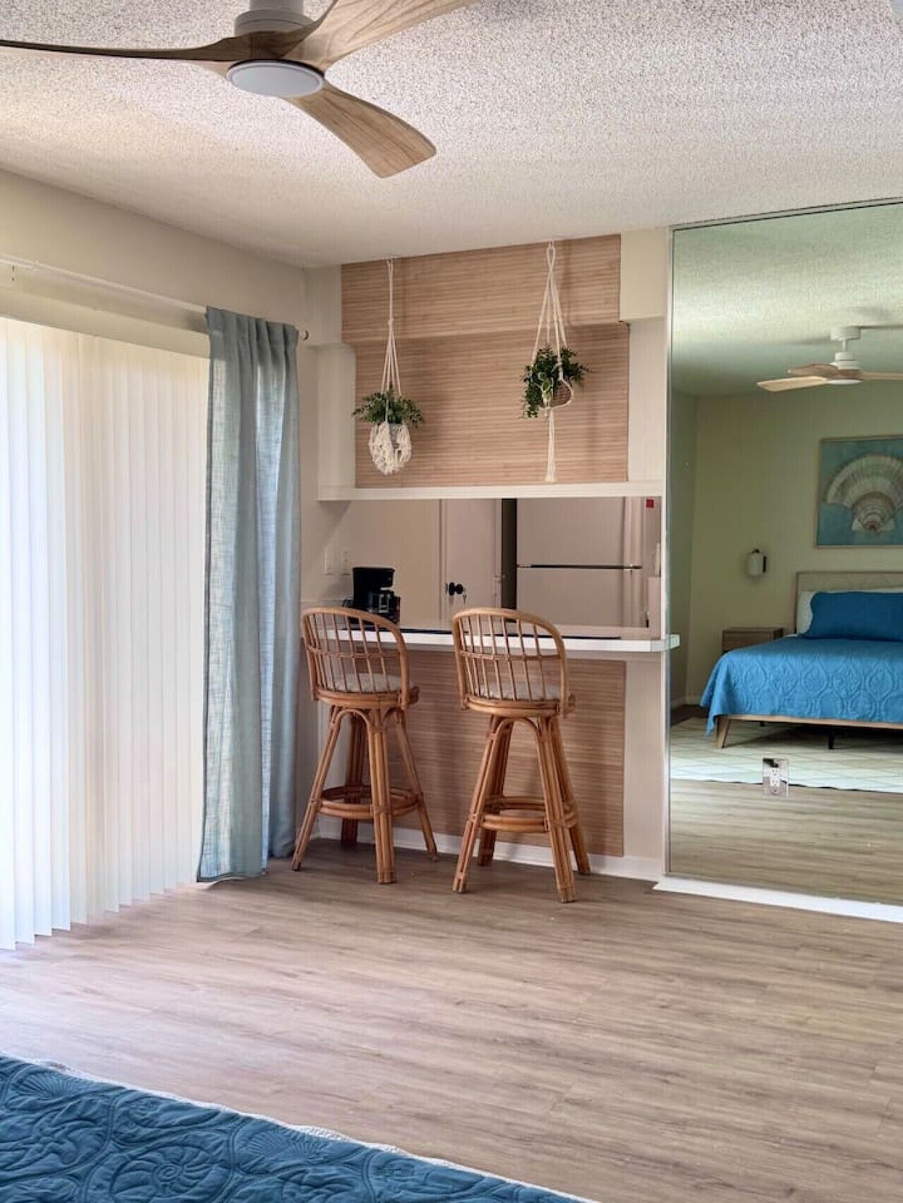Une chambre moderne comprenant un coin repas, un lit et un ventilateur de plafond.