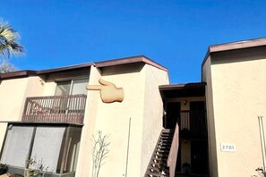 A building with a balcony and a staircase leading to an entrance. - Boho Coastal Studio • Near Siesta Key • Pool (Sarasota)