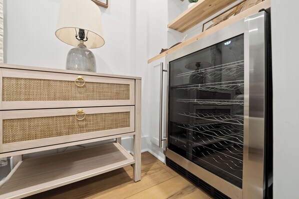 A kitchen with a built-in oven, a wooden cabinet with a woven front panel, and a hanging lamp.