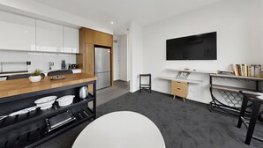 Una cocina moderna con armarios blancos, una encimera de madera y un horno empotrado.