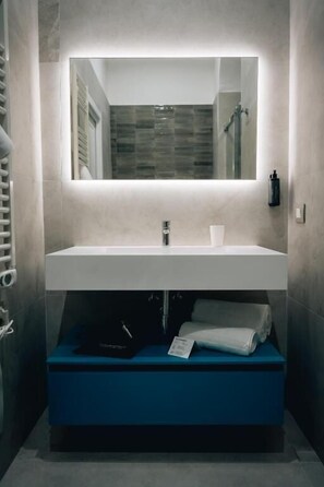 A modern bathroom with a built-in sink, a mirror, and a towel rack. - BnB Napoli Mobility (Naples)