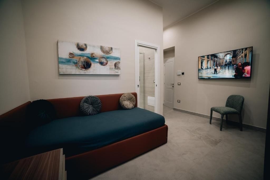 A modern living room with a sofa, a chair, and artwork on the walls.