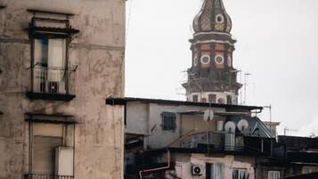 A building with a tower, balconies, and a weathered facade.