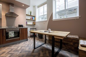 A modern kitchen with a wooden table, built-in oven, and a window with a view. - Near Cavern Club 2-storey Westminster (Liverpool)