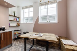 A compact kitchen with a wooden table, a bench, and a window with a view. - Near Cavern Club 2-storey Westminster (Liverpool)