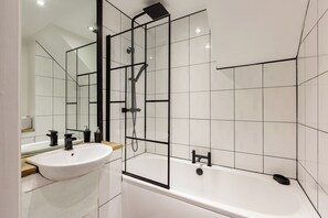 A modern bathroom with a white sink, a bathtub, and a glass shower enclosure. - Near Cavern Club 2-storey Westminster (Liverpool)