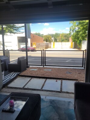 Un espace patio avec des sièges extérieurs, une vue sur une rue et un bâtiment avec une enseigne.