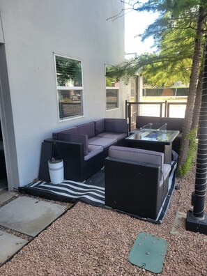 An outdoor seating area with a sofa and a table, surrounded by gravel and a small tree. - Delightful 2-bedroom apartment with AC in vibrant Downtown Dallas entertainment (Dallas)