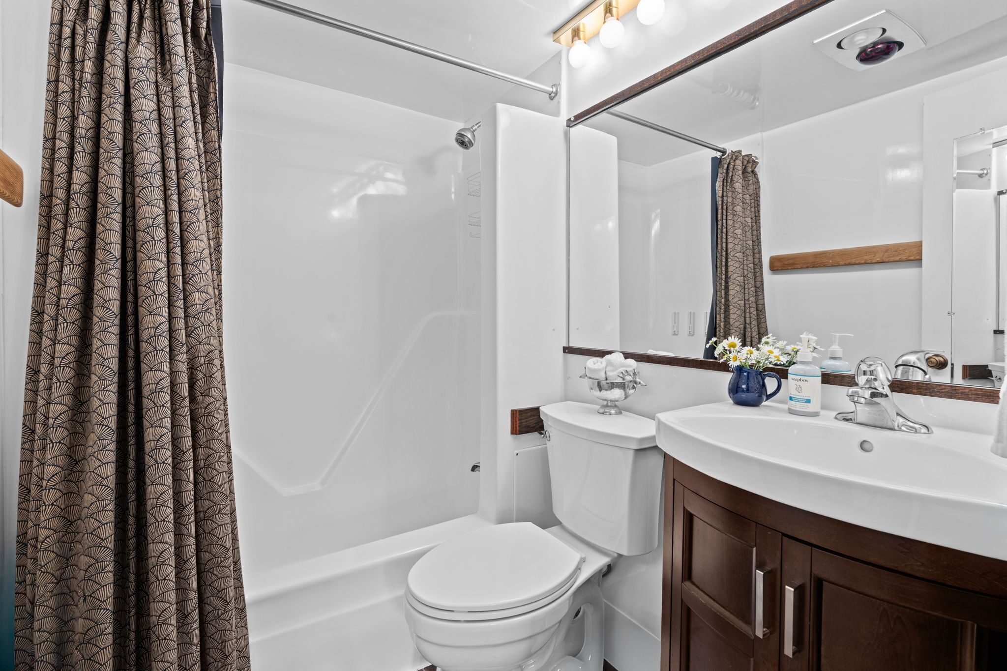 Une salle de bain moderne équipée d’une douche, de toilettes et d’un meuble-lavabo.