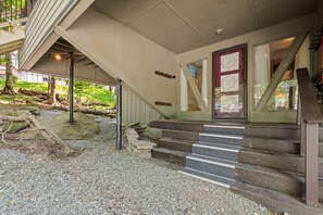 A staircase leading to a building entrance with a red door and a glass window.