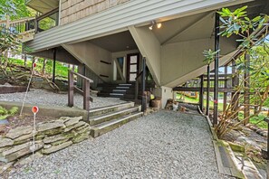 A building with a covered entrance, stone steps, and a gravel pathway.