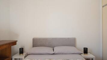 A bedroom with a bed, two bedside tables, and a nightstand.
