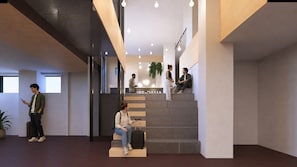 Een modern interieur met een trap, een persoon zittend op de treden en een andere persoon staand met een koffer.