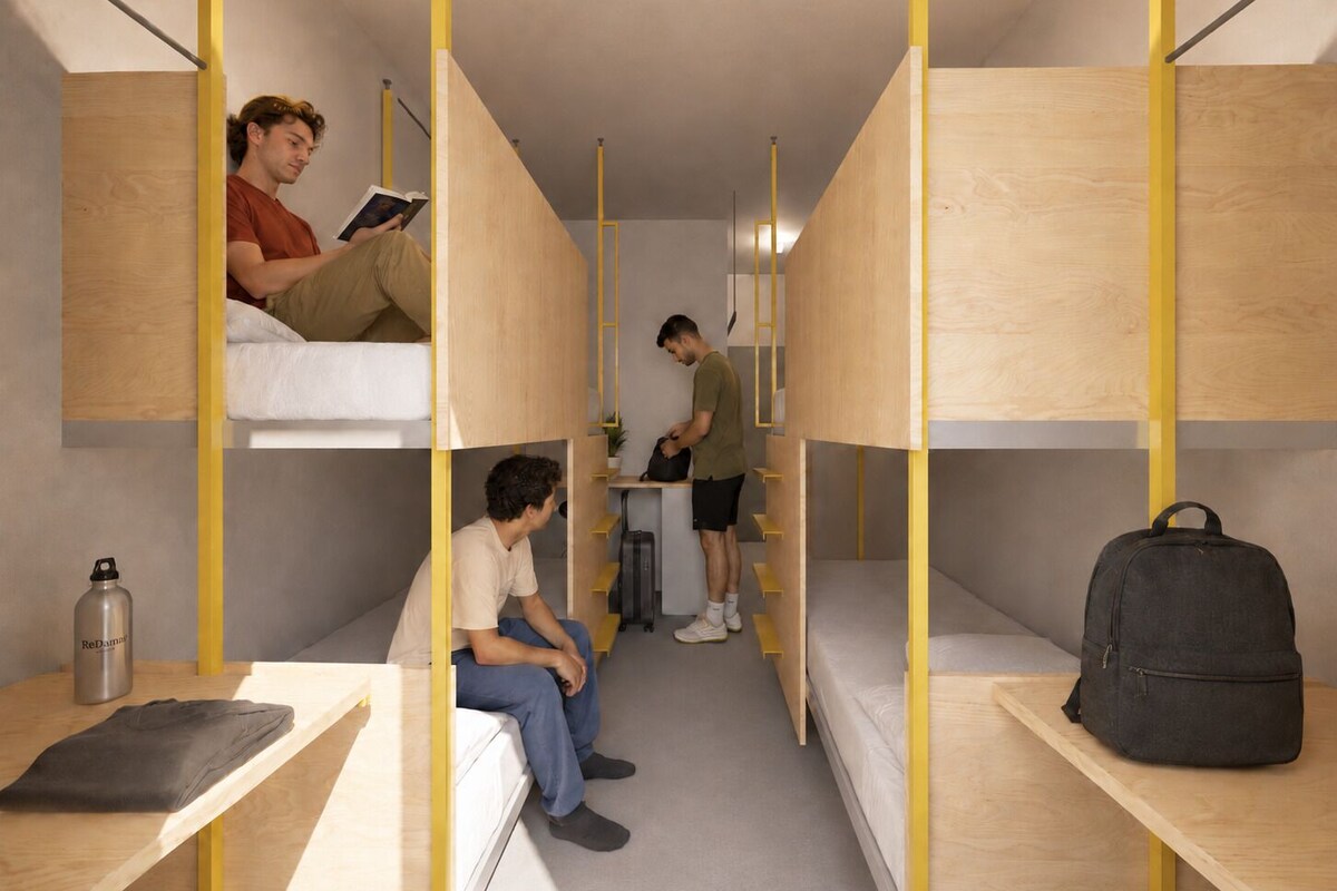 Een slaapzaal met stapelbedden, een bureau en een tafel.