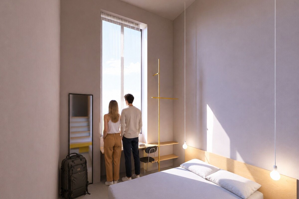 Een slaapkamer met een bed, een bureau, een stoel en een koffer.