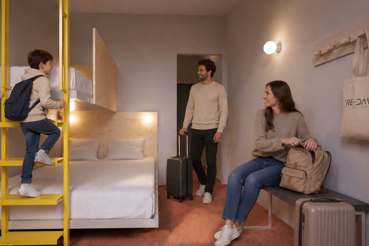 Een kamer met een stapelbed, een koffer, een bankje en een tasrek aan de muur.