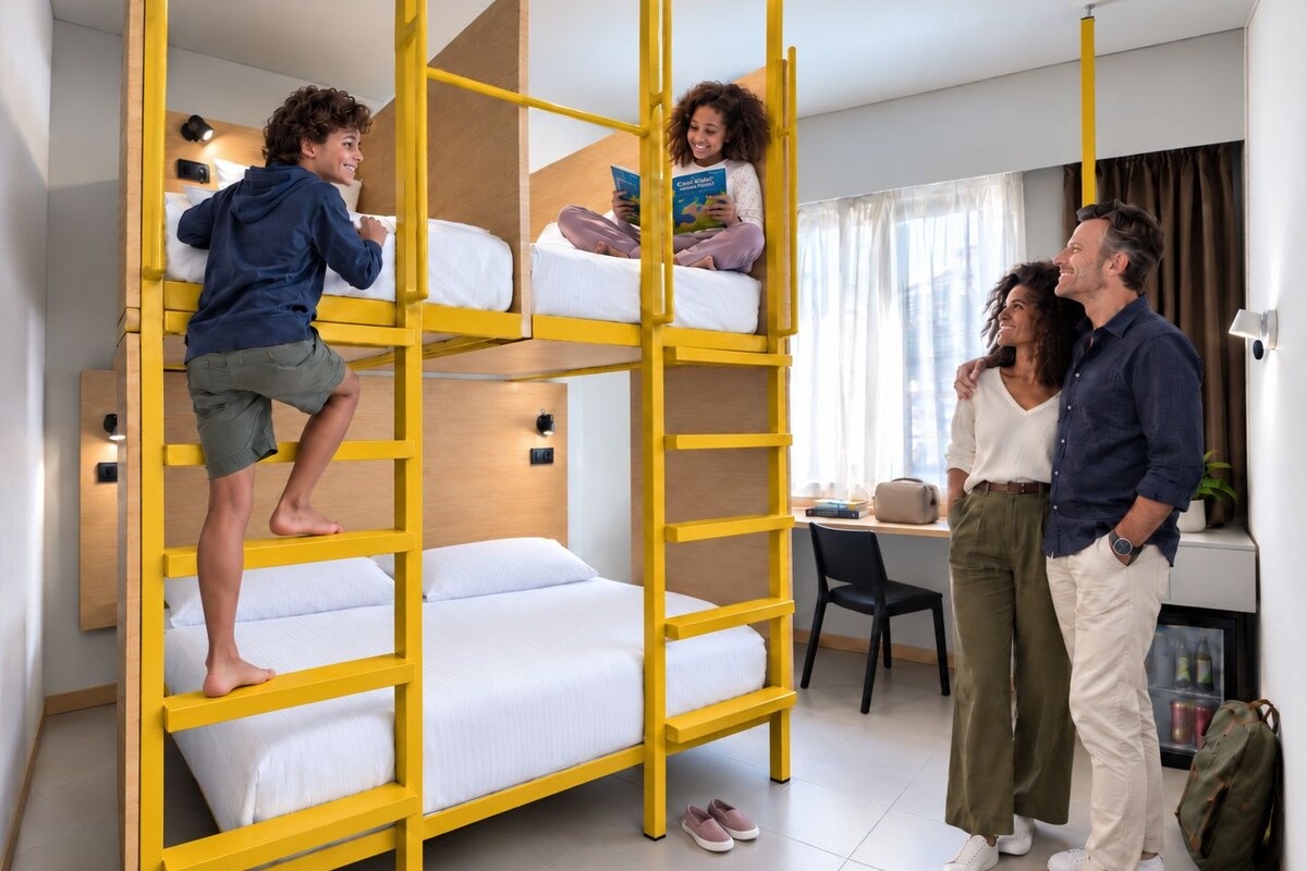 Een kamer met een stapelbed, een bureau en een stoel.
