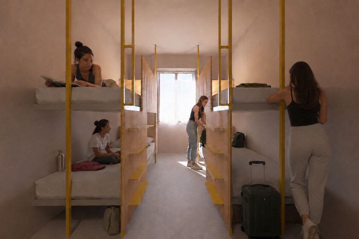 Een kamer in slaapzaalstijl met stapelbedden, een slaapbank en een koffer.