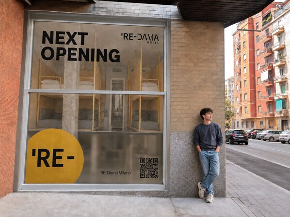 Hotelraam met een 'NEXT OPENING' bord, een QR-code en een gedeeltelijk zicht op de indeling van een kamer.