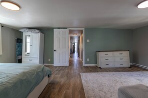 A bedroom with a bed, dresser, and a hallway leading to another room. - The Wildwood Escape!! Spacious 3BR + Sleeps 10 + Covered Deck (Wildwood)