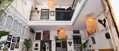 A multi-level interior with a dining area, a balcony, and decorative elements.