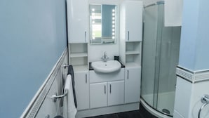 Ein Badezimmer mit Waschbecken, Spiegel und Dusche.