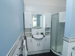 Ein Badezimmer mit Waschbecken, Spiegel und Dusche.