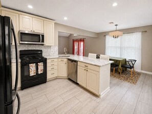 A modern kitchen with a built-in microwave, stove, and dishwasher.