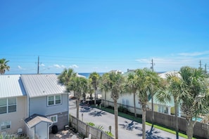Un barrio residencial con casas, palmeras y vista despejada al océano.