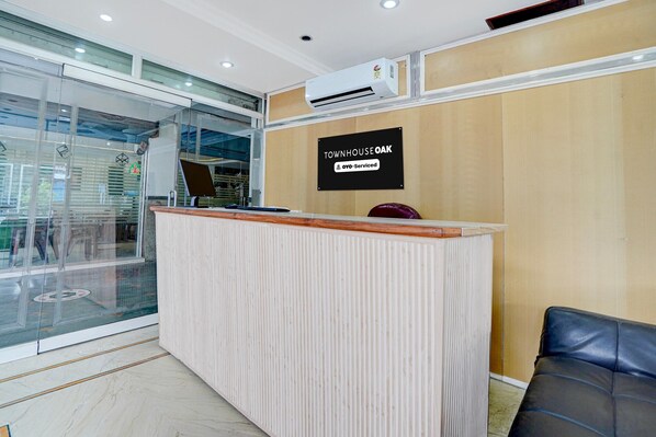Una mesa de recepción con un cartel que dice 'TOWNHOUSE OAK' y 'oyo-Serviced'.